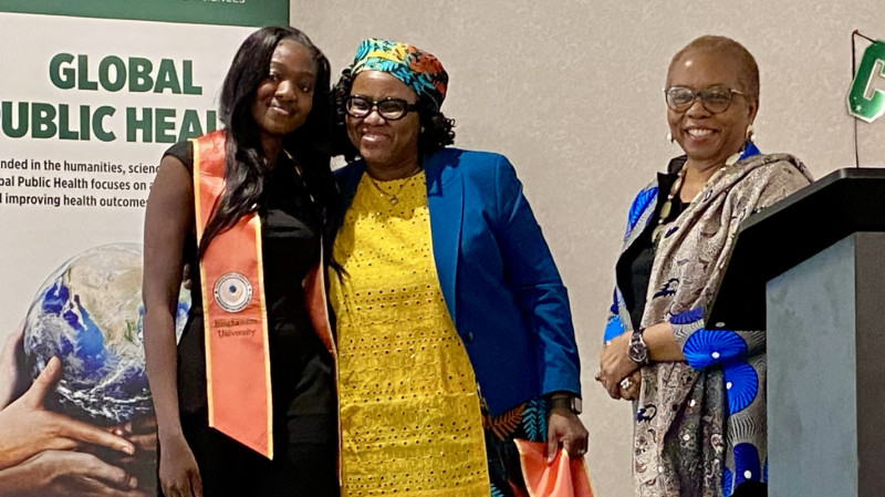 Professor Titilayo Okoror (center) and Distinguished Professor Nkiru Nzegwu (right) congratulate a graduate from the Global Public Health program at a ceremony on May 15, 2026, in the University Union.