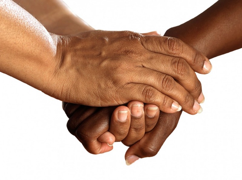 An image of two individuals holding hands.