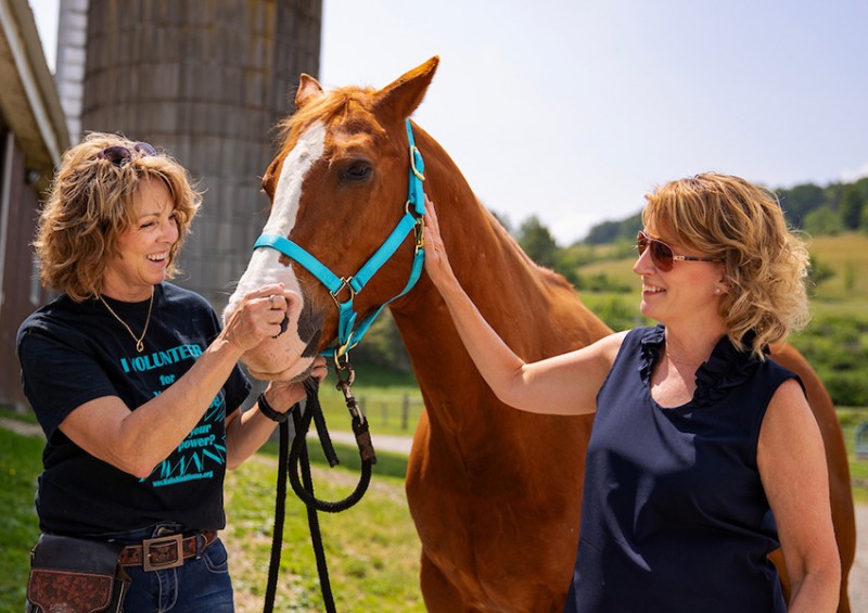 Linda Fargnoli, left, owner of Fargnoli Farms and executive director of Kali’s Klubhouse; Socks; and Tina Caswell, director of clinical education and a clinical associate professor of speech and language pathology at Decker College.