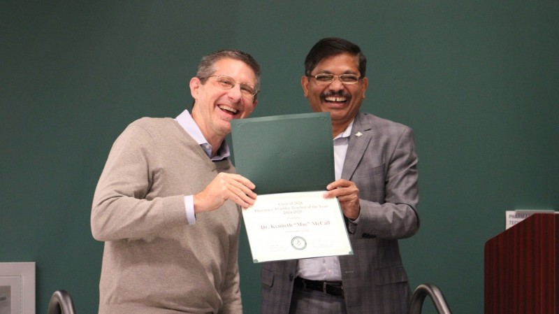 Chair and Clinical Professor of Pharmacy Practice Kenneth McCall accepting his Class of 2028 Best Teacher from the Pharmacy Practice Department award from Dean Nagaraju.