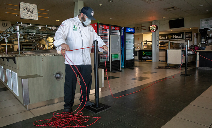 Thomas Dello, executive chef at Binghamton University Dining Services, installs rope and floor decals at the Appalachian Collegiate Center at Mountainview College.