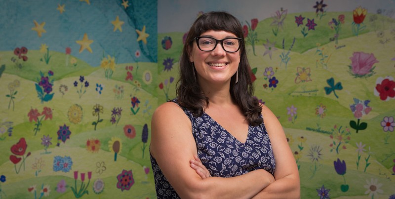 Decker College Clinical Assistant Professor Christina Muscatello ’08 developed an Arts in Healthcare minor that started in fall 2025. She's pictured in front of the “B in Bloom” mural at the Health Sciences Building. She designed the mural to display flowers created by faculty, staff and students that represent their heritage, background, identity or creativity.