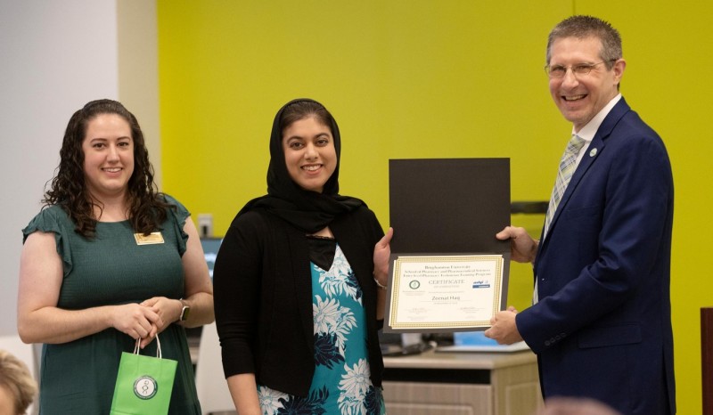 Pharmacy Technician Program graduate Zeenat Haq (center) receiving her certificate of completion from Program Director Kenneth McCall (right) and Instructional Support Associate Katie Sasina (left).