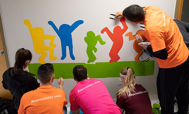 PwC Scholars paint murals on the walls of the HCA preschool in Johnson City, NY as part of a community-service project.