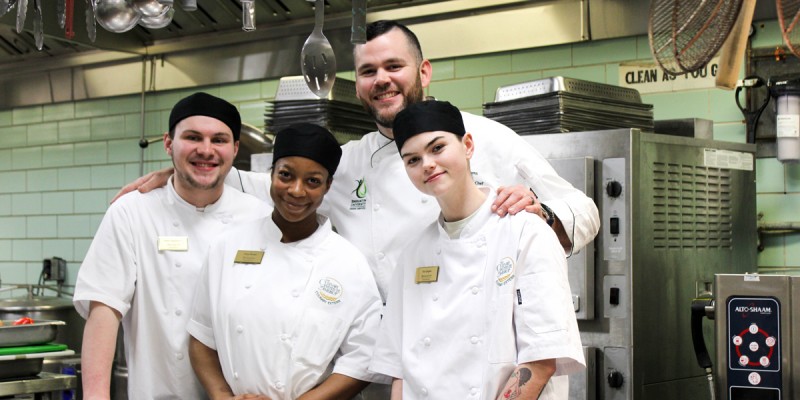 Culinary Institute of America students Dean Paquette, Cheya Brown and Eva Logios participated in the Binghamton University Dining Services externship program in spring 2023. They are pictured with Charlie Williams, campus executive chef.
