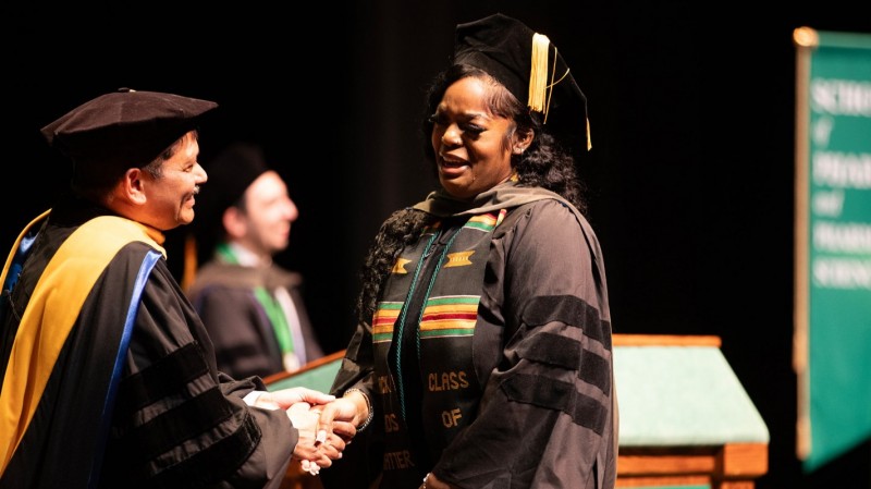Doctor of Pharmacy graduate Stephanie Nwachukwu is overcome with emotion after being hooded during the ceremony.