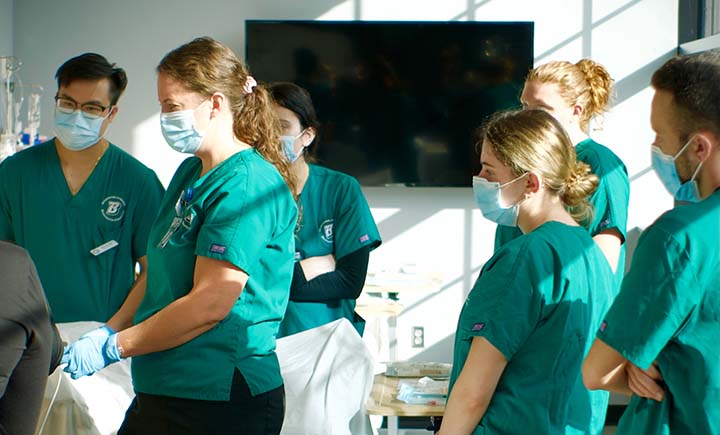 The dark green tops with Decker College logo and black scrub bottoms worn by students here are part of the required clinical uniform for undergraduate nursing students.