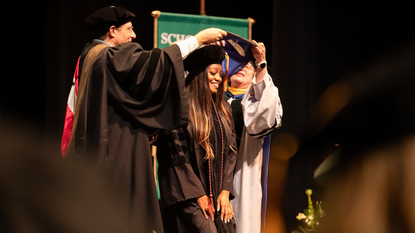 Doctor of Pharmacy graduate Ashanté Concepcion is hooded by Associate Professor Aaron Beedle and Clinical Professor Kenneth 