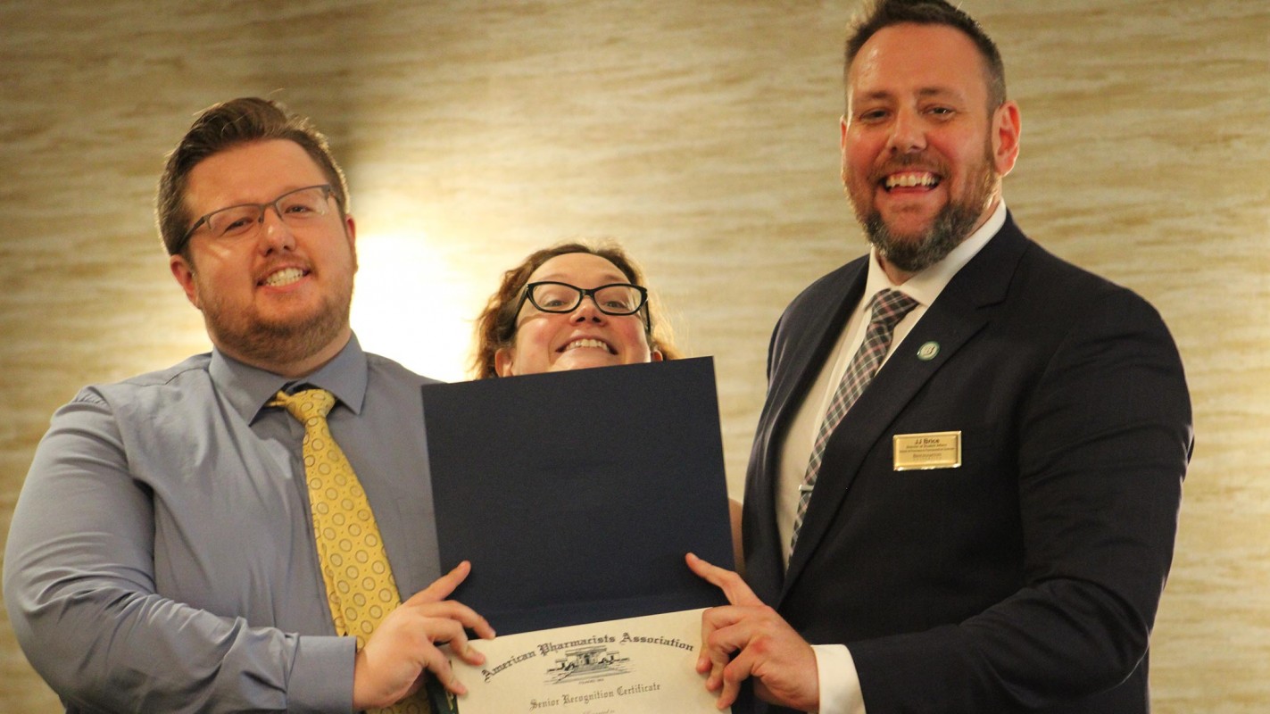 P4 student Ashton McCormack (left) accepts the Senior Recognition Award from the Administrative Coordinator of Student Affairs Amanda Padwa (middle) and the Director of Student Affairs James 
