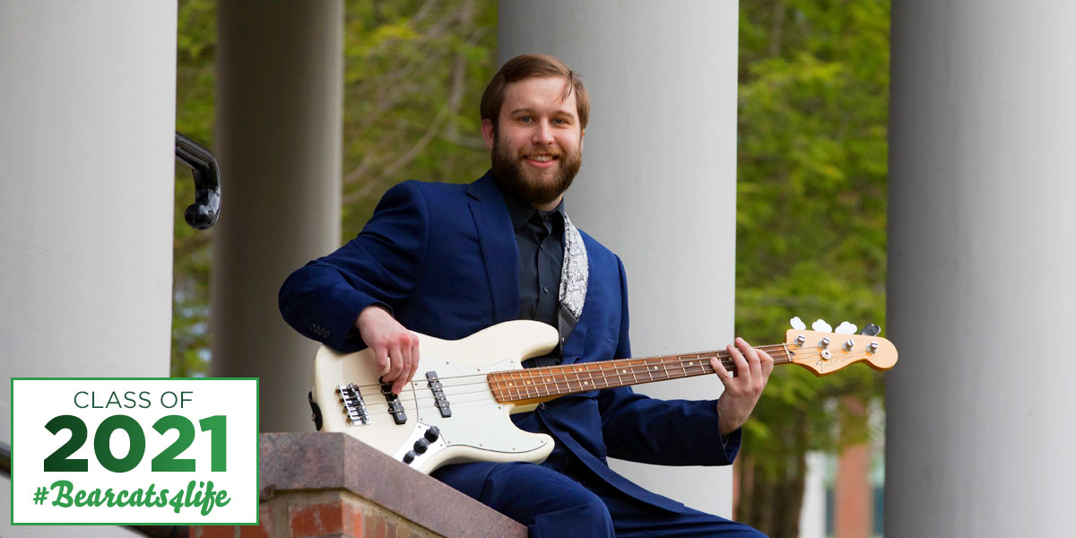 Benjamin Palmateer, a master's student in music composition with his bass guitar.