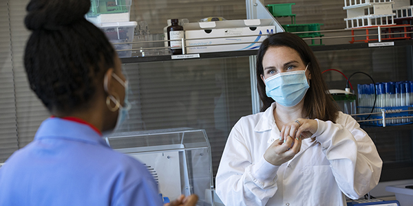 Binghamton biologist Laura Cook, at work in her lab with graduate student Lamar S. Thomas, was honored as an outstanding early-career researcher by the American Society for Microbiology.