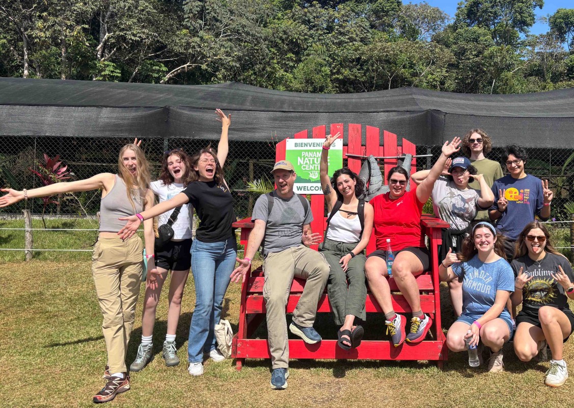 Earth Sciences doctoral candidate Jeanette deCuba, in the center of the red chair, poses with fellow shipmates in Panama before the STEMSEAS expedition in February 2026.