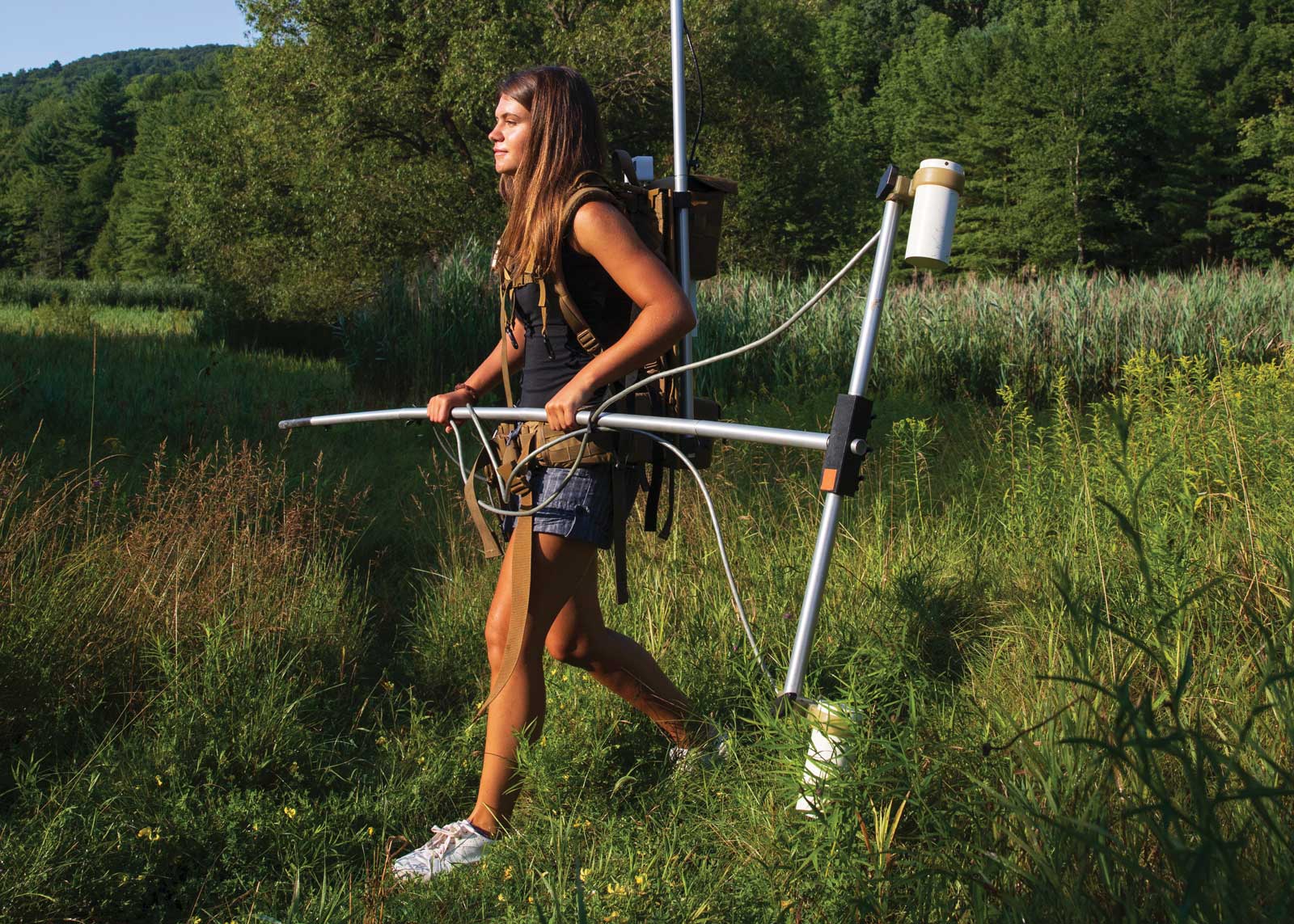 Natalia Romanzo, a master’s student in sustainable communities, is wearing about 40 pounds of equipment, including a magnetometer and a battery pack. The equipment is still being used, but drones are increasingly providing a more practical alternative.