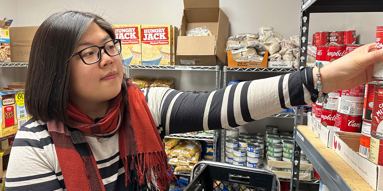 Emma Shen, eine Master of Public Health (MPH)-Studentin, arbeitet in einer Speisekammer der United Way of Broome County’s Healthy Lifestyles Coalition im Lee Barta Community Center in Binghamton.