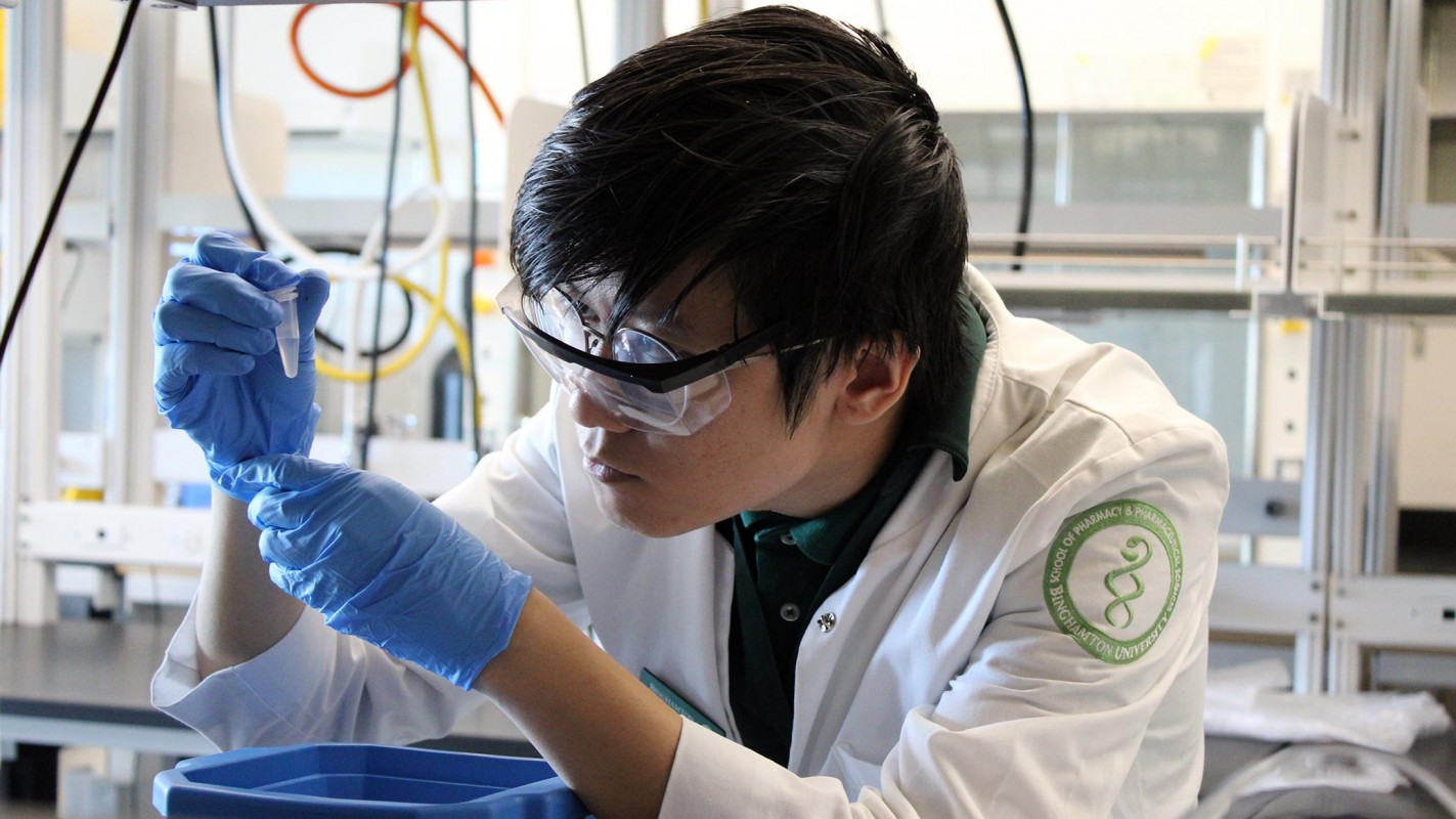 P3 student Felix Aung carefully examines a liquid during his research.