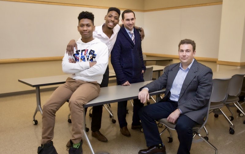Aleksey Tikhomirov (seated), visiting assistant professor of public administration, with students (L to R) Franklin Richards, Senegal Mabry and Jason Dearin