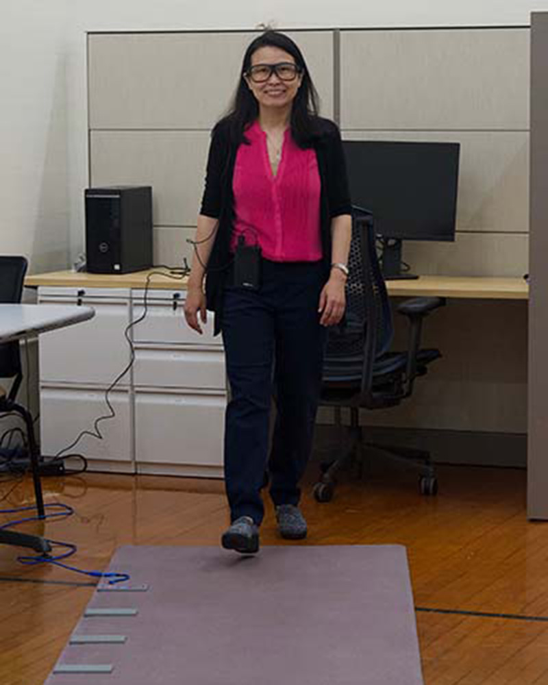 Patima Silsupidal, assistant professor of physical therapy, demonstrates the Portable GAITRite Platinum Plus System, a 14’ instrumented electronic walkway used in gait assessment.