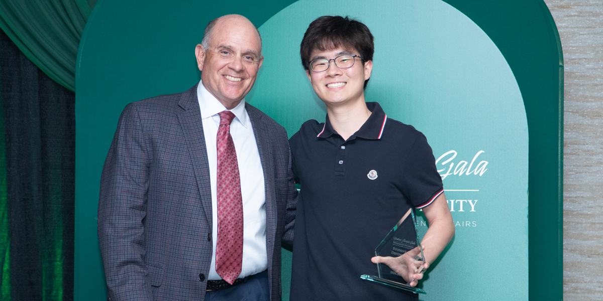Vice President for Student Affairs Brian Rose presents the Binghamton University Student of Distinction Award to Clay Jeon, a second-year philosophy, politics and law student.