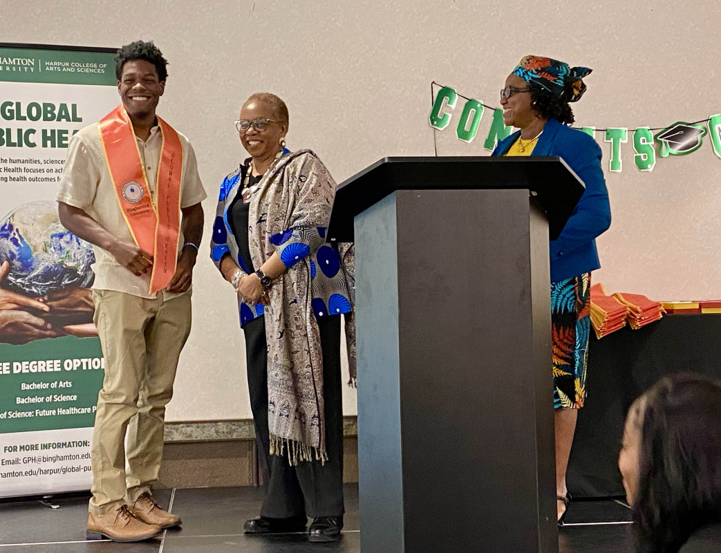Professor Titilayo Okoror (right) and Distinguished Professor Nkiru Nzegwu (center) congratulate a graduate from the Global Public Health program at a ceremony on May 15, 2026, in the University Union.