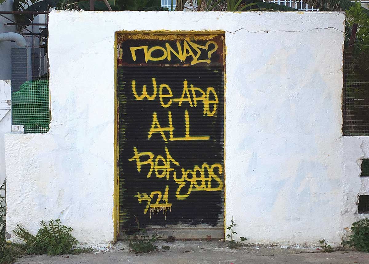 Graffiti on a door in Leros reads: We are all refugees.
