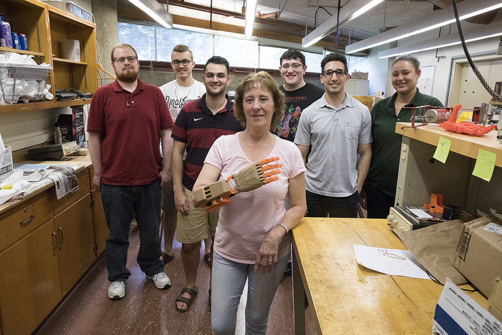 A team of Watson School of Engineering and Applied Sciences Biomedical Engineering majors, Adam Adler, Jacob Praga, Trey McIntyre, Jacob Vogel, Nico Summa and Victoria D'Ambrosio build a prosthetic hand for Dining Services employee Sue Riegel, pictured here in the Engineering Building, May 1, 2017.