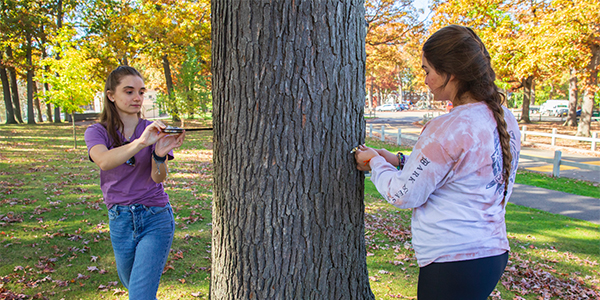 Katie Cassidy and Christina Nonnenmacher, students in Sara Velardi’s ENVI 382E: Ecology of the Northeast class, measure the DBH (diameter at breast height) of the tree using DBH tape, which eliminates the need for the user to divide by 3.14 to find the tree’s diameter. Their class was helping the city of Binghamton update an inventory of tree species at Rec Park in Binghamton.