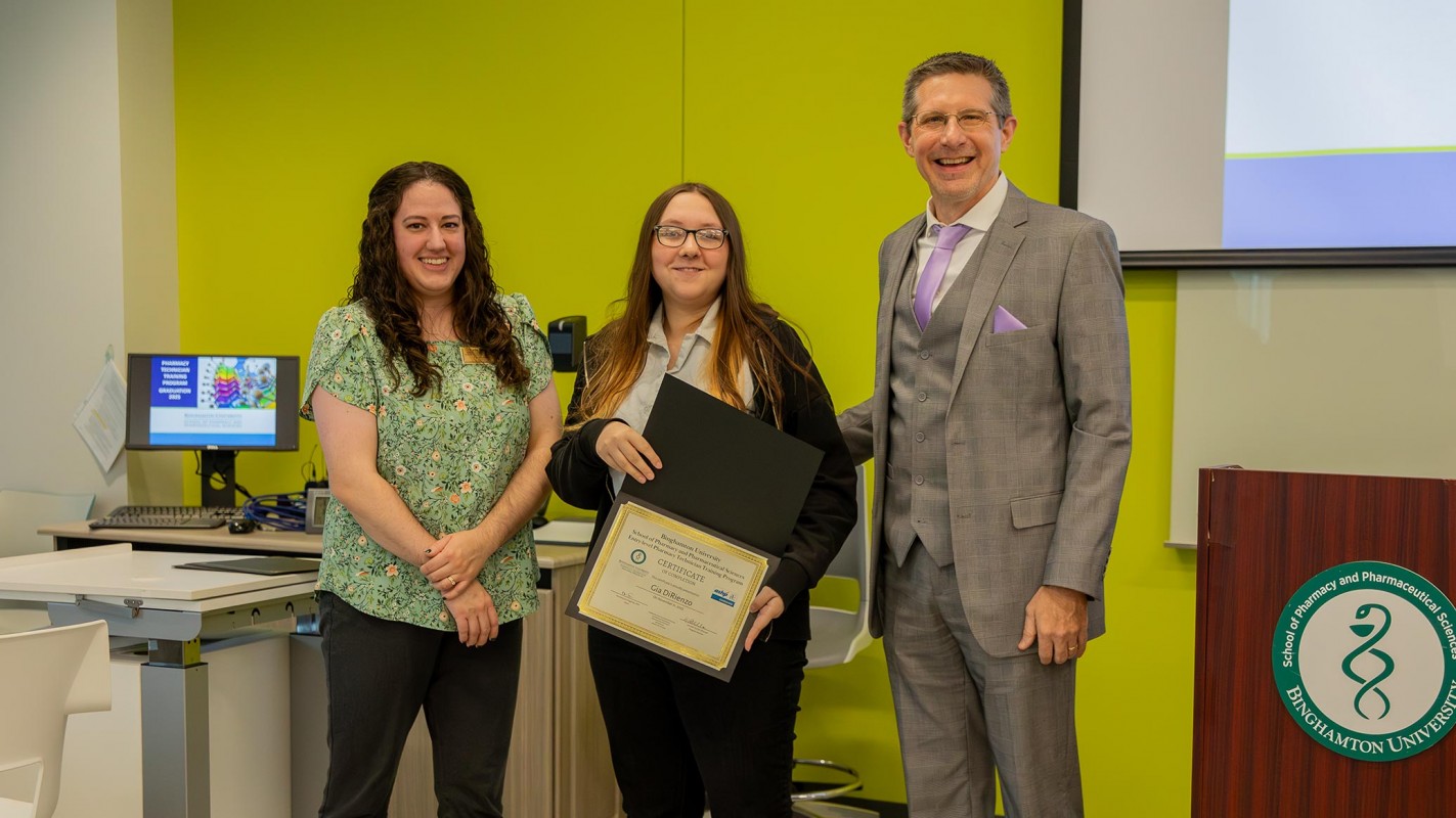 Instructional Support Associate Katie Sasina (left) and Program Director Kenneth McCall (Right) stand with Pharmacy Technician Program Graduate Gia DiRienzo (center) after receiving her certificate of completion.