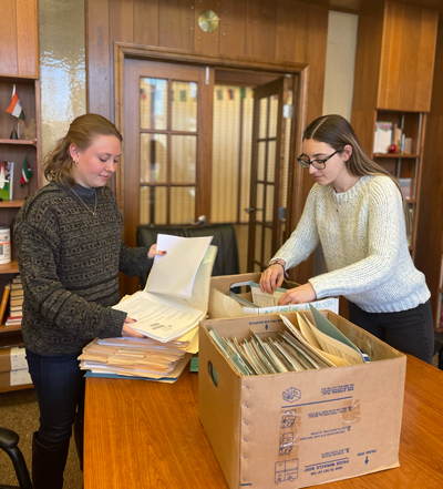 Kara Chadwell and Leticia Fabene (right), immigration interns at the ACA, organize client files.
