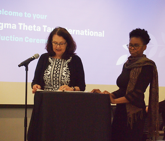 Nicole Rouhana, MS '95, PhD '11, associate professor and director of graduate programs, presents Marjorie Menardy Magloire with the Excellence in Advanced Nursing Practice Post-Master's Certificate Award.