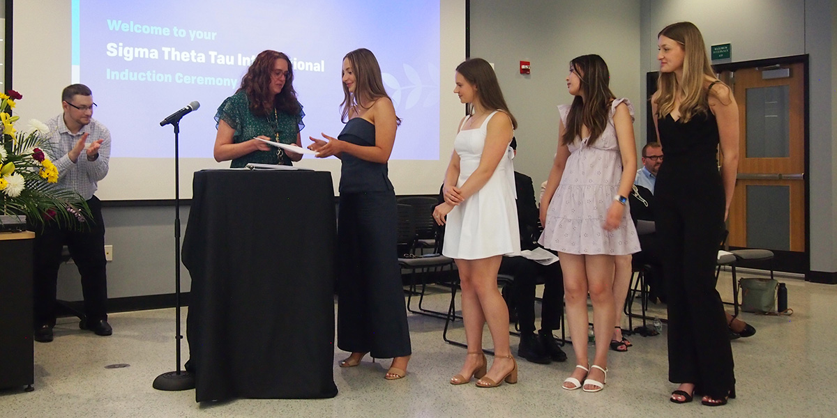 Ann Fronczek, MS '99, associate professor and director of undergraduate and doctoral nursing programs, presents the Decker School of Nursing Award to seniors Sierra Devlin, Katie Kaufman, Victoria Yu and Mariella Michitti (from left).