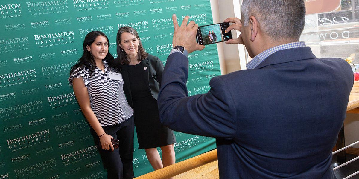 Mehul Thakkar, a member of the Parents Leadership Council, takes a photo of his daughter, Aarya Thakkar '29, an integrative neuroscience major from Plainsboro, New Jersey, with President Anne D'Alleva during the Parent and Family Programs banquet held in April.