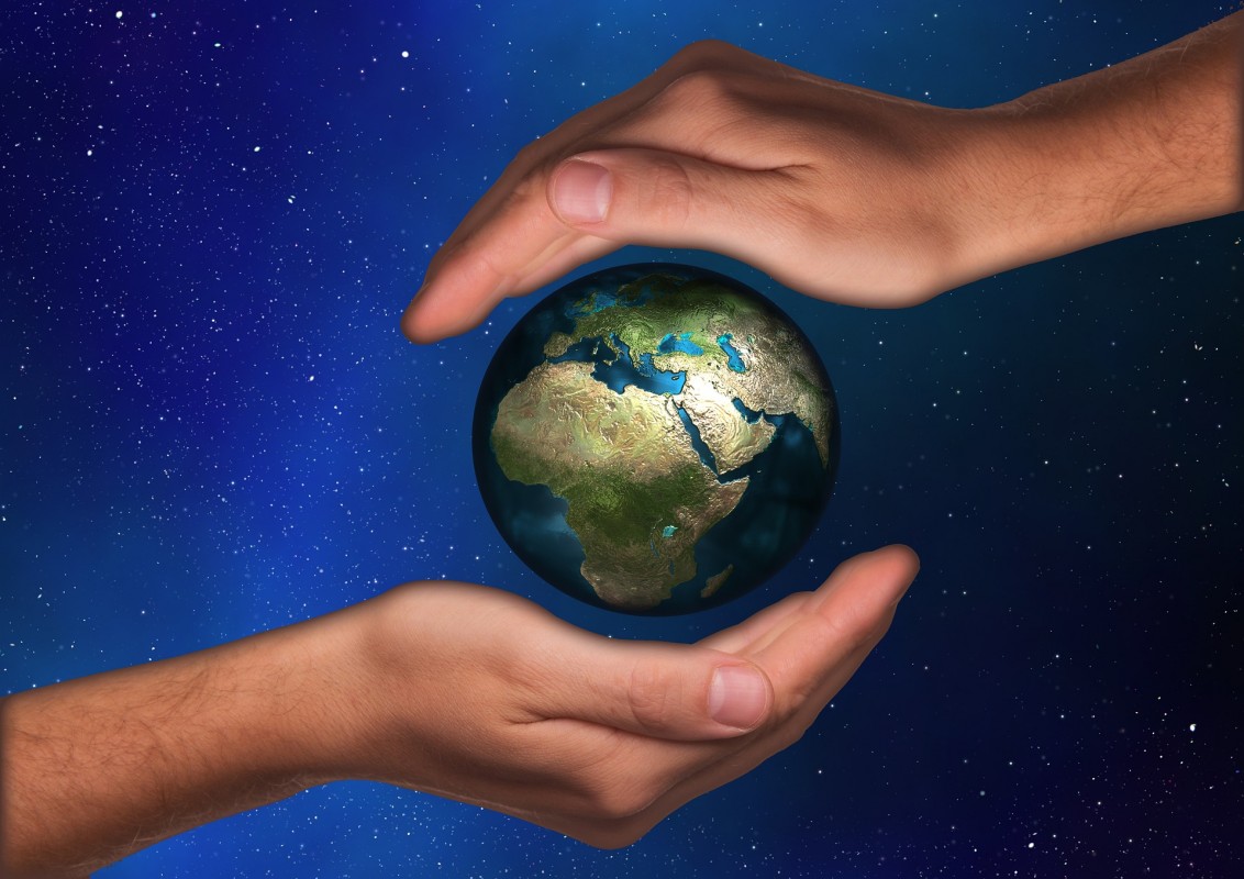 An illustration of two hands surrounding the Earth.