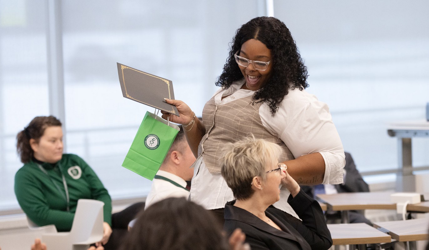 Pharmacy Technician Program graduates Sharavia (Rae) Weathers and Teresa Swankoski give each other a high five after receiving their certificates of completion.