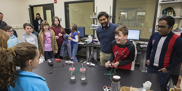 Graduate students Nahid Hasan, left, and Nabid Hossain demonstrate how they convert mechanical vibrations into electrical energy during a field trip for children from Tioga Hills Elementary School in late April.