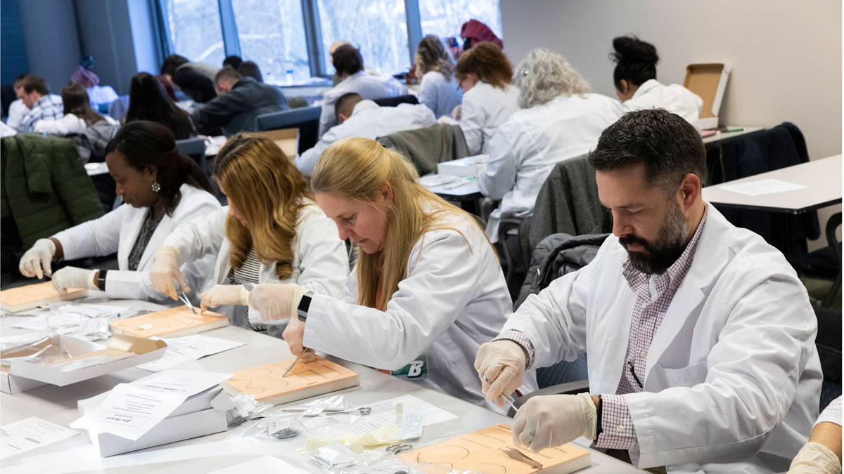 Nurse practitioner students at the Decker School of Nursing participate in a day-long advanced skills workshop. Here, students practice suturing skills.