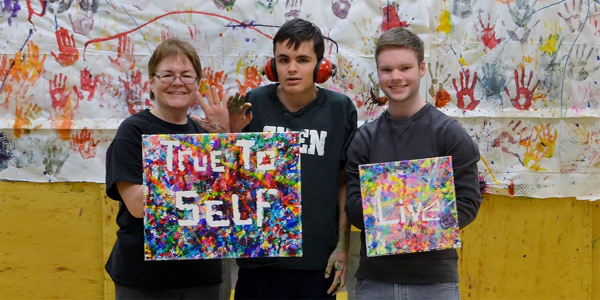 Kayden Stockwell (right) with Susan and Michael J. Adinolfe at the Magic Paintbrush Project, a former nonprofit focused on family engagement and supports for individuals with special needs.