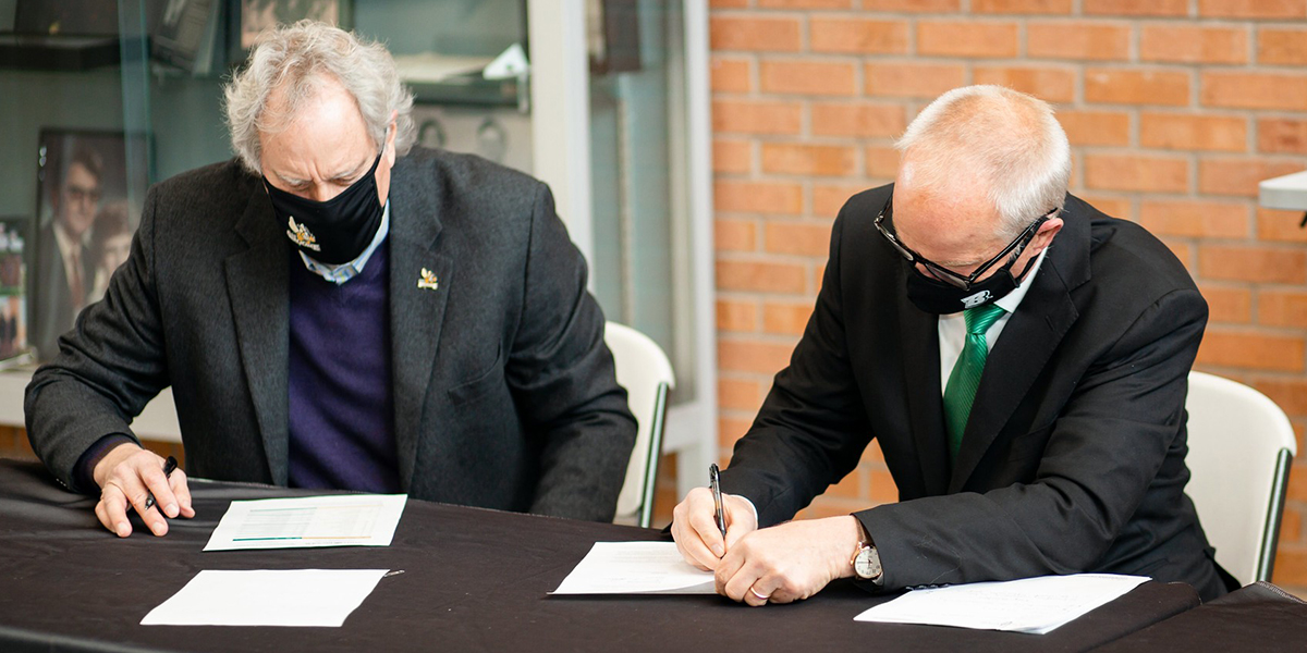 SUNY Broome Community College President Kevin Drumm and Binghamton University President Harvey Stenger sign the articulation agreement.