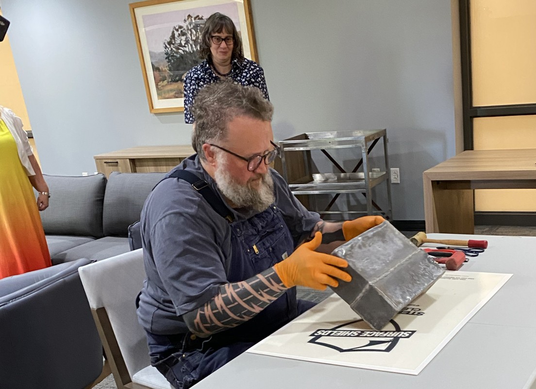 Jeremiah Brown from the Harpur College Fabrication Lab opens a time capsule discovered in Science 1.