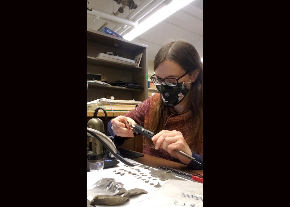Doctoral candidate in anthropology Michele Troutman works with stone tools that are part of the Iroquois Indian Museum’s collection.