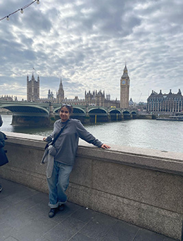 A woman standing on a bridge on a cloudy day