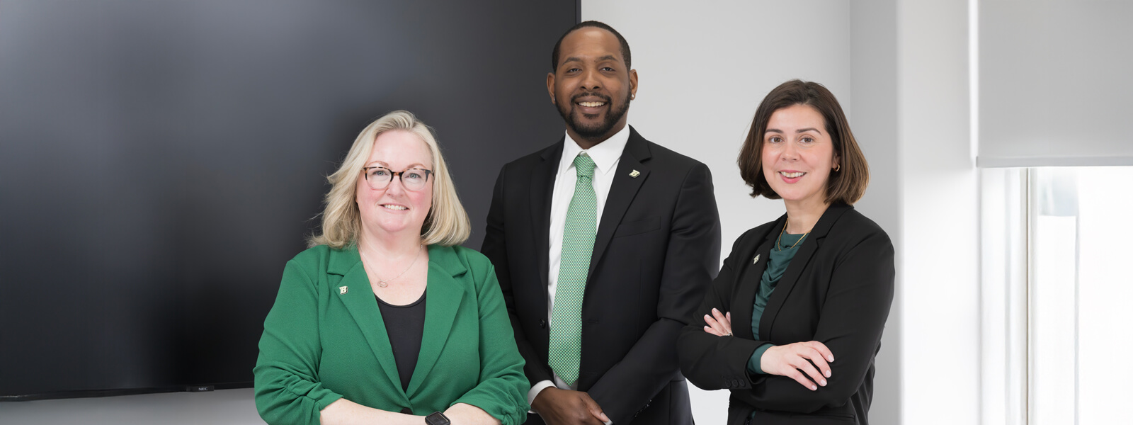 Sharon, Andre and Diana standing near a conference table