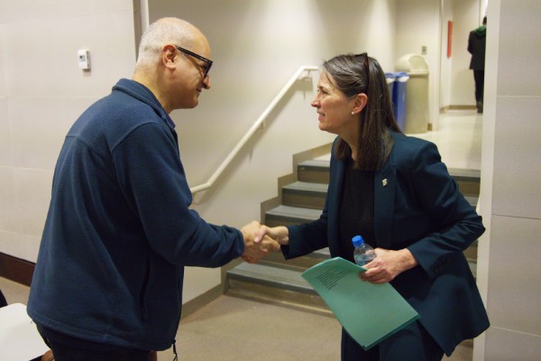 President Anne D'Alleva shakes hands with a faculty member from the School of Management