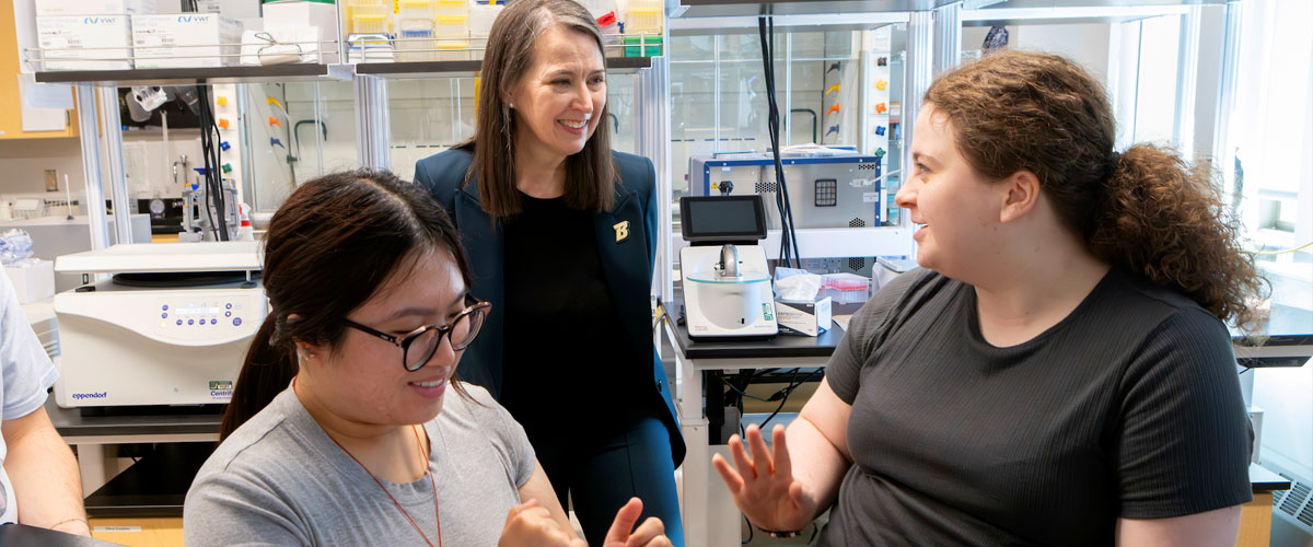 President Anne D’Alleva meets with students in a lab.