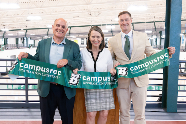 Vice President for Student Affairs Brian Rose, President Anne D'Alleva, and Director of Campus Recreational Services Tom St. John hold a ribbon at the reopening of the East Gym.