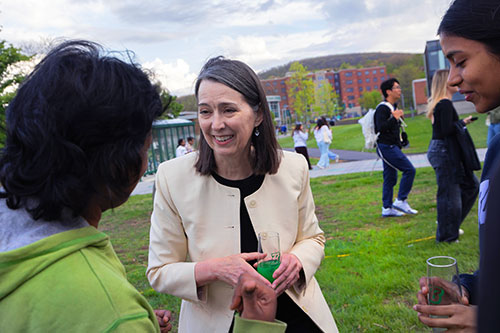Anne talking to two other students outside with bright green drink