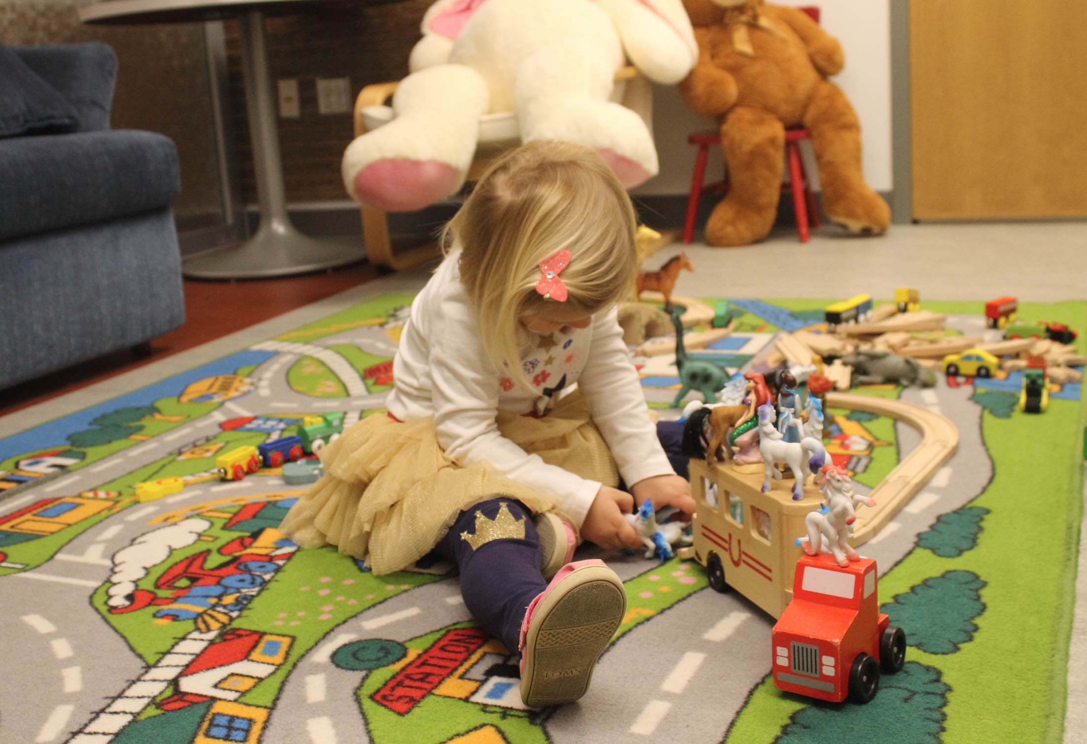 Girl playing with toys in colorful playroom