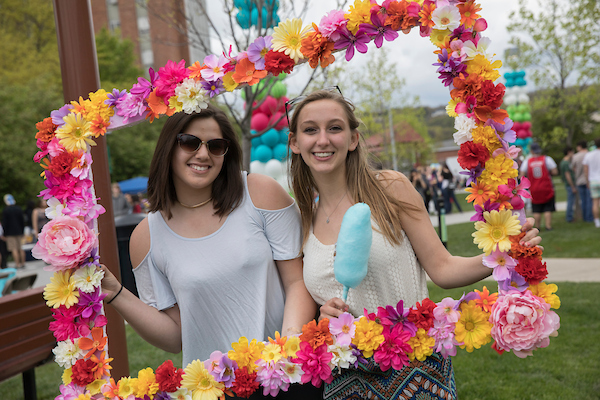 Two students posing in a flower frame.