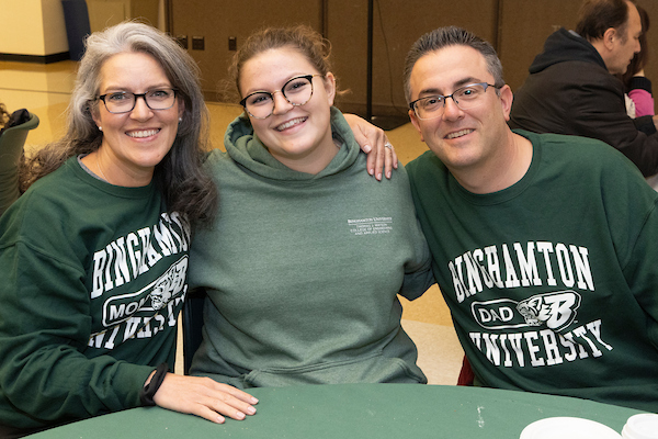 A family smiling during Family Weekend.