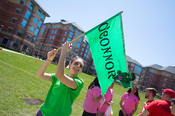 Students competing in Mutant Mania, holding a team flag.