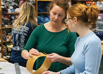 Faculty member and student collaborating on a textile design project in a studio.